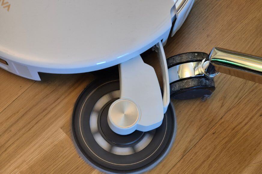MOVA V70 Ultra Complete mit vollständig ausgefahrenem MaxiReachX Wischarm an einem Stuhlbein auf Hartboden